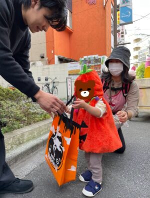 ハロウィンイベントでお菓子を渡す髙田トレーナー